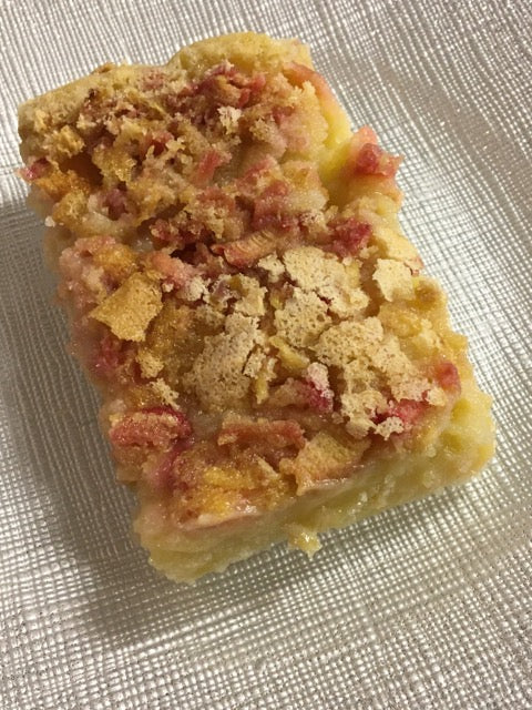Rhubarb bar with butter tart-like filling sitting ona white and silver plate.