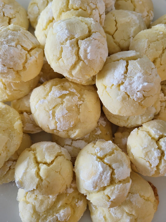 A plate of cookies topped with icing sugar.