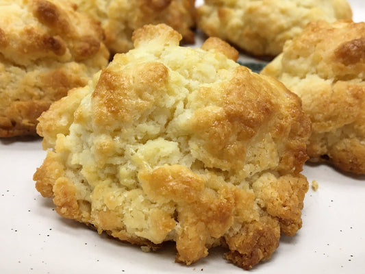 Golden baked biscuits on a white plate.