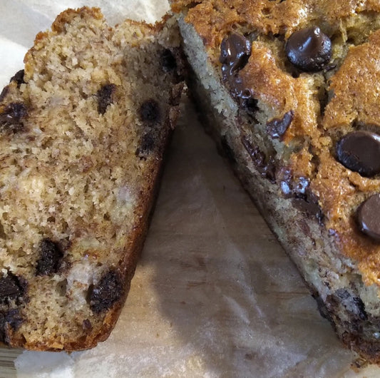 chocolate chip banana bread sliced on a parchment lined board.