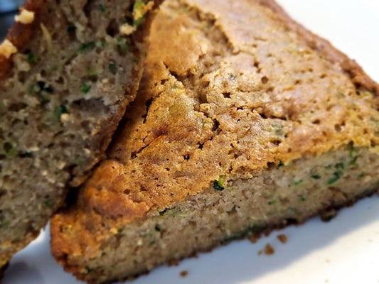 Sliced loaf of zucchini bread on a white plate.